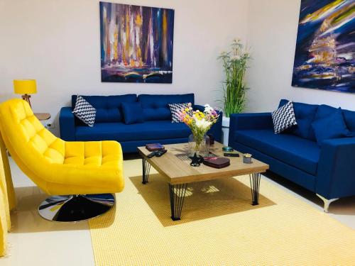 a living room with two blue couches and a yellow chair at New cosy 2 bedrooms in La Marsa in La Marsa