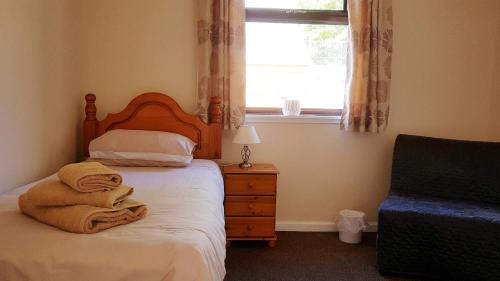 1 dormitorio con 1 cama con toallas en Myrtle Cottage en Johnshaven