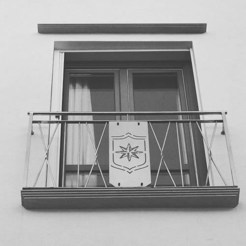 a window with a clock on a balcony at Imera B&B in Favignana
