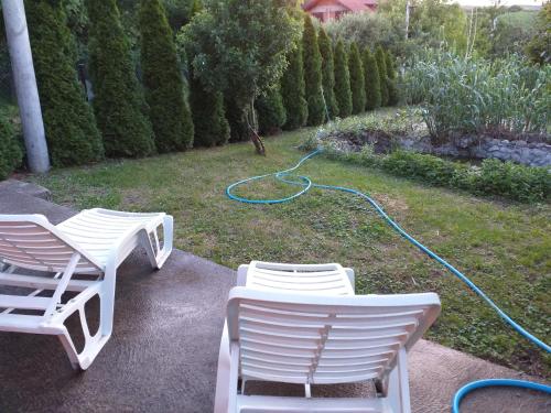 two lawn chairs and a hose on the grass at Sweet dreams in Zaječar