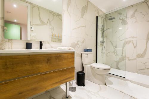 y baño con lavabo, aseo y ducha. en Les Lofts St-Roch - Par Les Lofts Vieux-Québec, en Quebec
