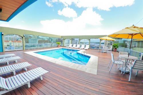 - une terrasse avec une piscine dans un bâtiment dans l'établissement Ritter Hotéis, à Porto Alegre