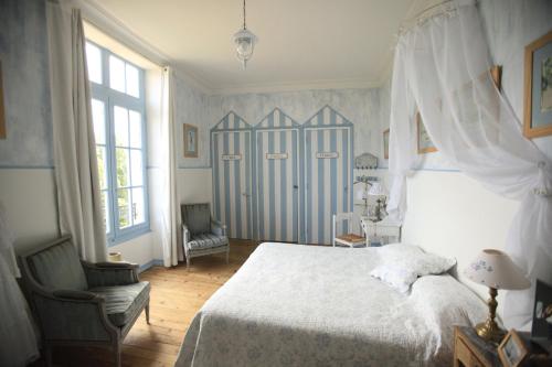 a bedroom with a white bed and a chair at Chateau De La Moriniere in Beaupréau