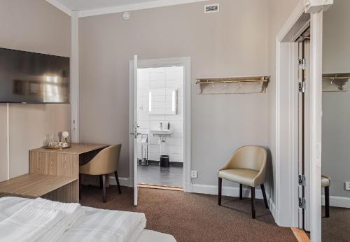 a bedroom with a bed and a desk and a table at Livgrenadjärmässen Hotell-Fest-Konferens in Linköping