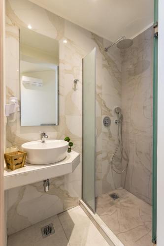 a bathroom with a sink and a shower at Estian Deluxe in Limenaria