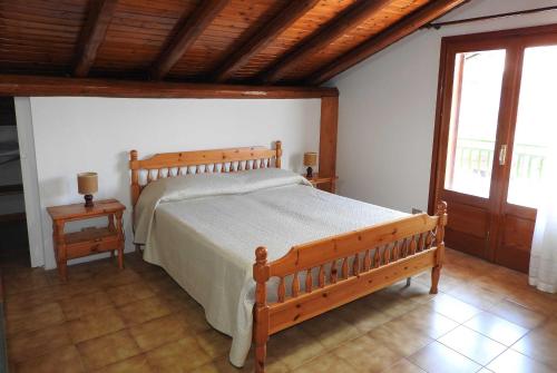 ein Schlafzimmer mit einem Holzbett und einer Holzdecke in der Unterkunft Mansarda sul mare dei Ciclopi in Acitrezza