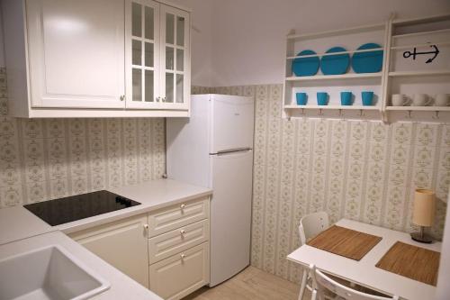 a kitchen with white cabinets and a white refrigerator at Old Town Apartment next to Seafront Promenade in Nafplio