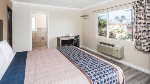a bedroom with a large bed and a window at Sea Rock Inn - Long Beach in Long Beach