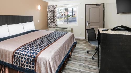 a hotel room with a bed and a desk at Sea Rock Inn - Long Beach in Long Beach