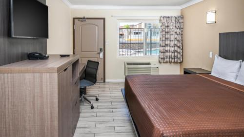 a hotel room with a bed and a desk at Sea Rock Inn - Long Beach in Long Beach