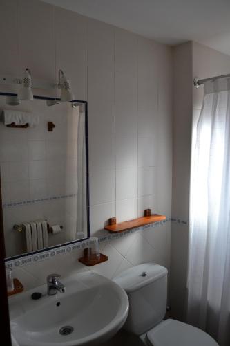 a bathroom with a sink and a toilet and a mirror at Los Palacios in Albarracín