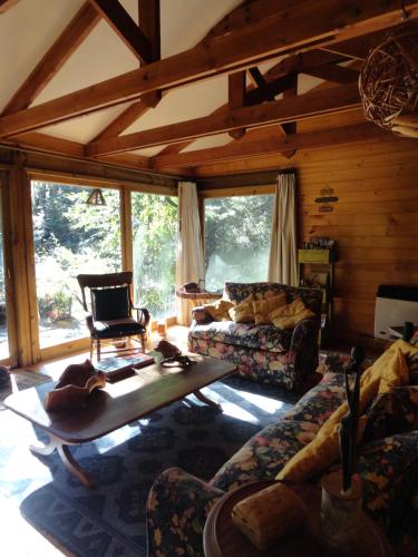 a living room with a couch and a chair at Linda Cabaña en Reserva HuiloHuilo in Puerto Fuy