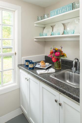 a kitchen with white cabinets and a sink and a window at Waldo Emerson Inn in Kennebunkport