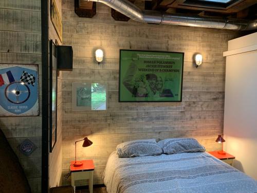 Dormitorio con cama y póster en la pared en Classic Driver Home 1 en Royat