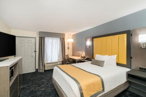 a hotel room with a bed and a television at Baymont by Wyndham Franklin in Franklin