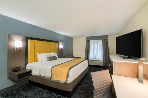 a hotel room with a bed and a flat screen tv at Baymont by Wyndham Franklin in Franklin