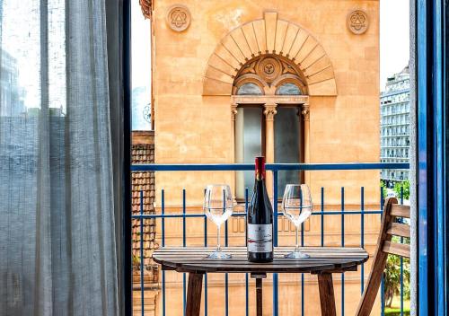 einen Tisch mit einer Flasche Wein und zwei Gläsern in der Unterkunft Le stanze di Irma in Palermo