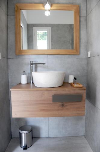 une salle de bain avec un lavabo et un miroir dans l'établissement Les Suites d'Agosta, à Porticcio