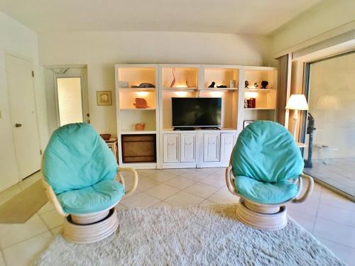- deux chaises assises dans un salon avec une télévision dans l'établissement Siesta Key Beach 5830 #T34, à Siesta Key