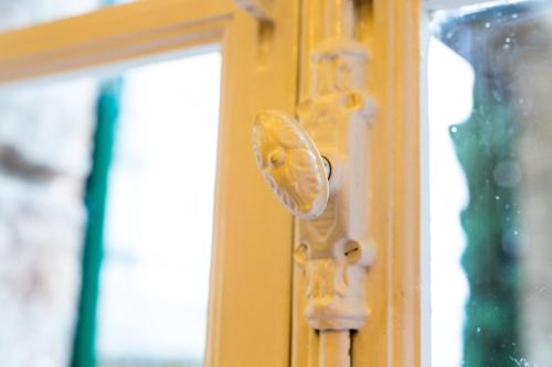 a door knob on a yellow door at Room En Suite la Corte Assisi in Assisi