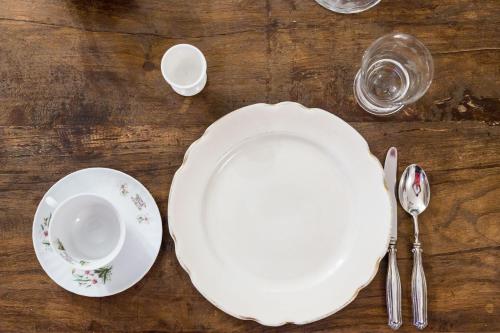 a table with white plates and silverware on it at Room En Suite la Corte Assisi in Assisi