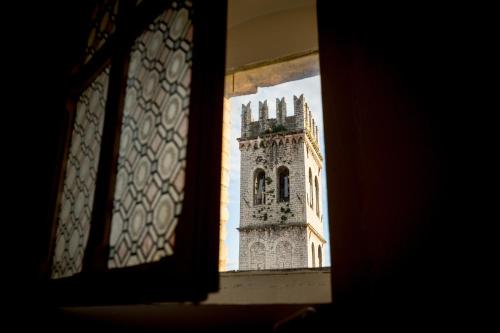 a view of a clock tower through a window at Room En Suite la Corte Assisi in Assisi