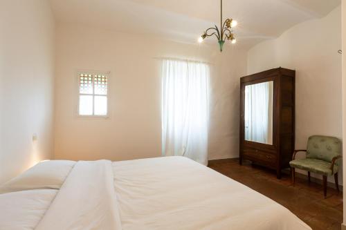 a bedroom with a bed and a chair and a window at Room En Suite la Corte Assisi in Assisi