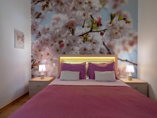 a bedroom with a bed with a flowering tree behind it at Onyx City Center Apartment in Heraklio