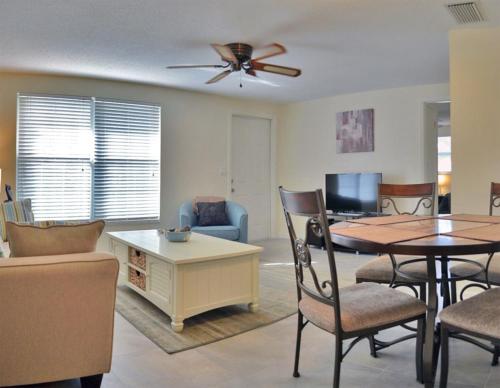 a living room with a table and chairs and a ceiling fan at One Ocean - A 1101 in Sarasota