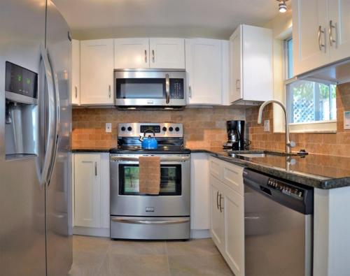 a kitchen with white cabinets and stainless steel appliances at One Ocean - A 1101 in Sarasota