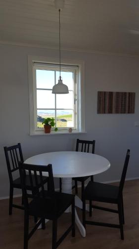 a dining room with a table and chairs and a window at Gíslaholt in Borgarnes