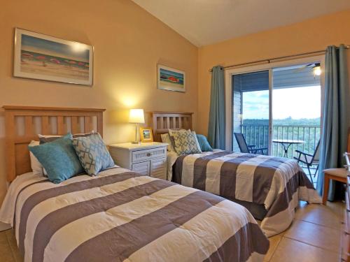 two beds in a room with a balcony at Holmes Beach - Mangroves 3607 #208 in Holmes Beach