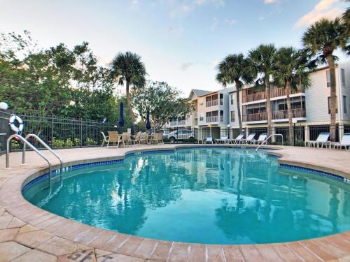 a large swimming pool in a courtyard with palm trees at Holmes Beach - Mangroves 3607 #208 in Holmes Beach