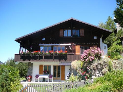 a house with a balcony with flowers on it at Chalet Acheregg in Wengen