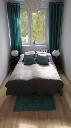 um quarto com uma cama grande e cortinas verdes em Sea & Sand Apartment em Gdansk