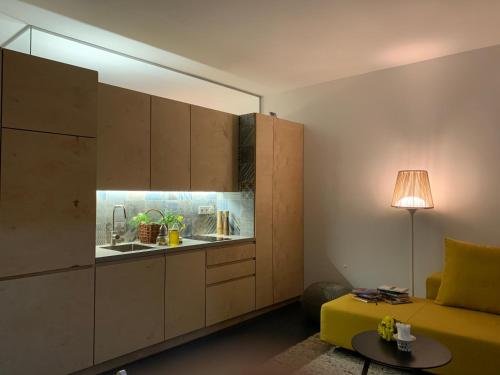 Zimmer mit einer Küche mit einem Sofa und einem Tisch in der Unterkunft Genius Guest Unique Banovci Apartment in Banovci
