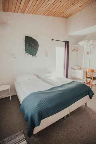 a bedroom with a bed with a green blanket on it at Birkilauf in Myvatn