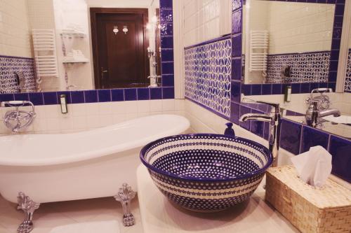 a blue and white bathroom with a tub and a sink at Ekosamotnia in Kraków