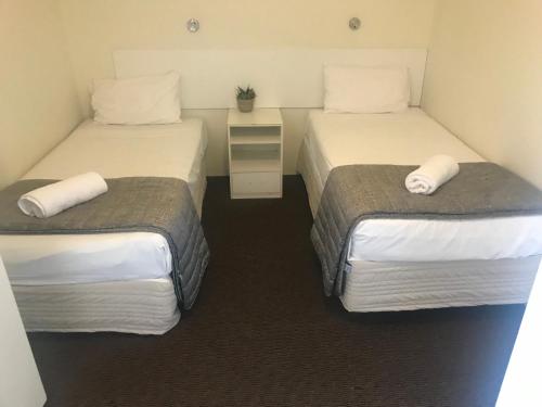 two beds in a small room with two beds sidx sidx sidx at Blue Pelican Motel in Tweed Heads