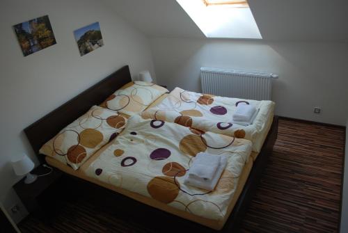 a small bedroom with a bed with a blanket at Penzion Na Dědině in Mutěnice