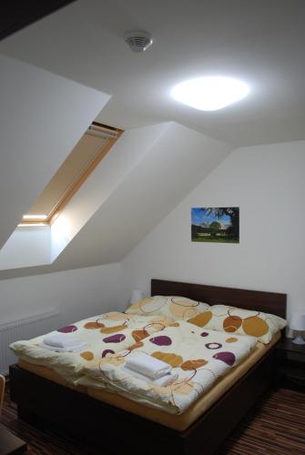 a bed sitting in a room with a ceiling at Penzion Na Dědině in Mutěnice