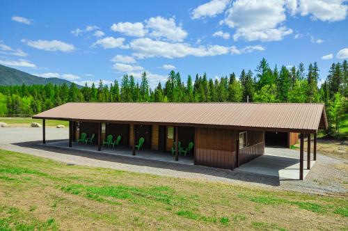 a small building with green chairs in a field at Glacier Homestead in Coram