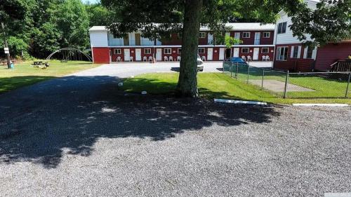 a tree in front of a building with a playground at Red Ranch Inn in Catskill