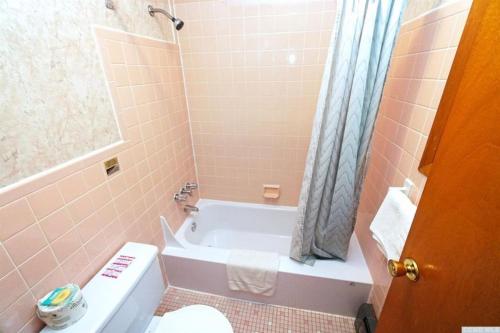 a bathroom with a tub and a toilet and a sink at Red Ranch Inn in Catskill