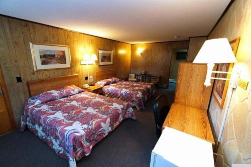 a hotel room with two beds and a desk at Red Ranch Inn in Catskill