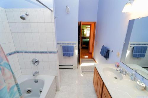 a white bathroom with a tub and a sink and a tub at Red Ranch Inn in Catskill