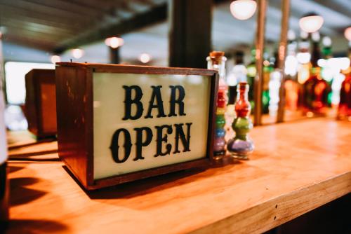 a bar open sign on top of a wooden table at Rainbow Mountain Resort - LGBTQ Friendly in East Stroudsburg