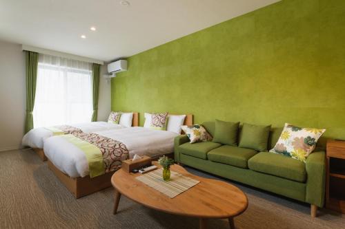 a hotel room with a bed and a couch at GRAND BASE Mojiko in Kitakyushu