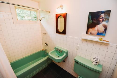 a bathroom with a green tub and a sink at Rainbow Mountain Resort - LGBTQ Friendly in East Stroudsburg
