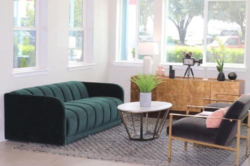 a living room with a green couch and a table at Arya Inn and Suites in Irving